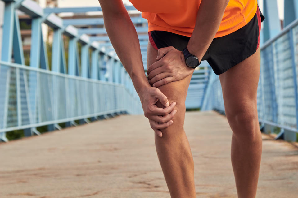 Sportsman with leg injury during jogging and exercising in urban environment.