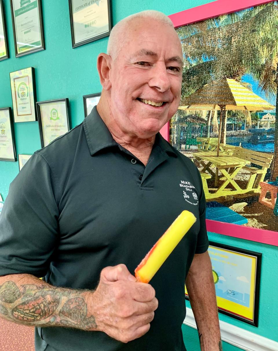 “Deli Mike” Duclos, who recently closed his Beachside Grill & Deli in Cocoa Beach's Cape Royal Building, holds up one of the free popsicles he gave out with meals.