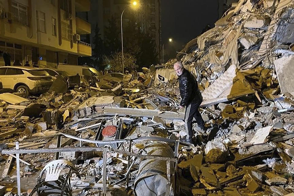 A man searches collapsed buildings in Diyarbakir, southern Turkey, early Monday, Feb. 6, 2023. A powerful earthquake has caused significant damage in southeast Turkey and Syria and many casualties are feared. Damage was reported across several Turkish provinces, and rescue teams were being sent from around the country. (Depo Photos via AP)