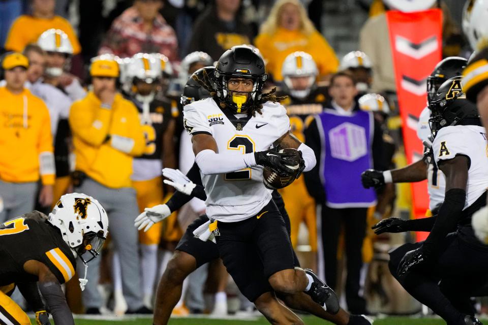 Sep 23, 2023; Laramie, Wyoming, USA; Appalachian State Mountaineers cornerback Tyrek Funderburk (2) makes an interception and runs for a touchdown against the Wyoming Cowboys during the fourth quarter at Jonah Field at War Memorial Stadium. Mandatory Credit: Troy Babbitt-USA TODAY Sports