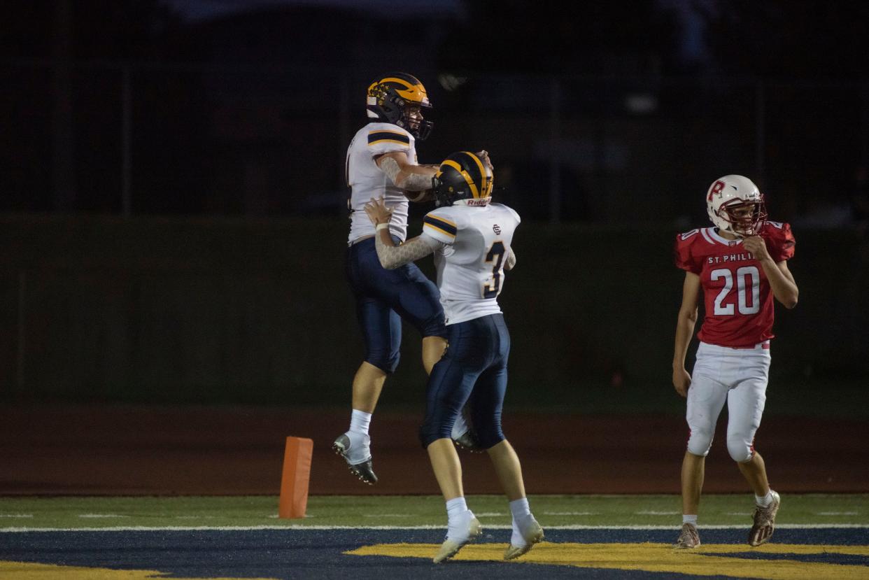 Climax-Scotts sophomore Luke Lawrence and senior Daniel Matrau celebrate a touchdown during a game against St. Philip at C.W. Post Field on Friday, Sept. 16, 2022.