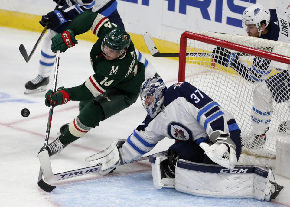 Winnipeg Jets goalie Connor Helebuyck (37) makes a save on a shot by Minnesota Wild center Joel Eriksson Ek in the second period of a hockey game Sunday, Sept. 29, 2019 in St. Paul, Minn. (AP Photo/Andy Clayton-King)