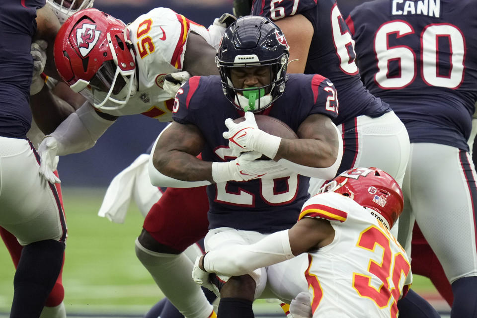 Houston Texans running back Royce Freeman (26) is stopped by Kansas City Chiefs linebacker Willie Gay (50) and cornerback L'Jarius Sneed (38) during the first half of an NFL football game Sunday, Dec. 18, 2022, in Houston. (AP Photo/Eric Christian Smith)