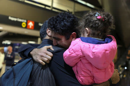 Iranian citizen and U.S green card holder Cyrus Khosravi (C) greets his brother, Hamidreza Khosravi (L), and niece, Dena Khosravi (R), 2, after they were detained for additional screening following their arrival to Seattle-Tacoma International Airport to visit Cyrus, during a pause in U.S. President Donald Trump's travel ban in SeaTac, Washington, U.S. February 6, 2017. REUTERS/David Ryder