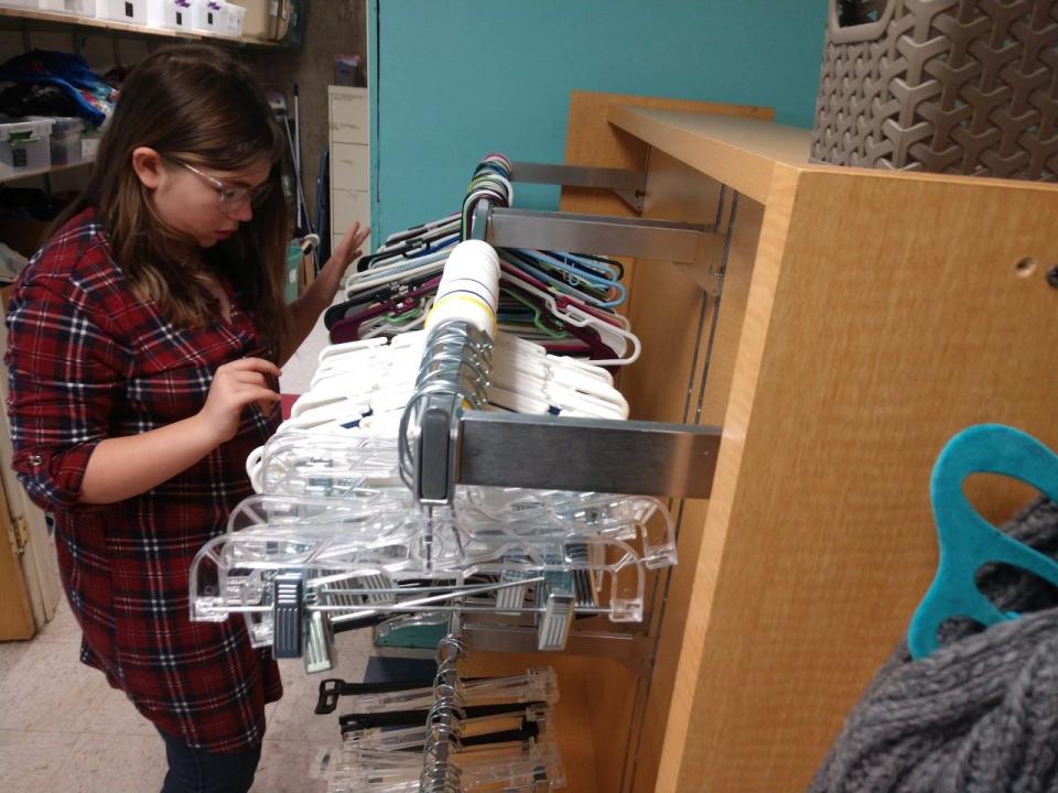 Penelope Vernon, 11, sorts through hangers at Tabitha’s Closet. The free clothing closet is run out of the Afton Methodist Church.