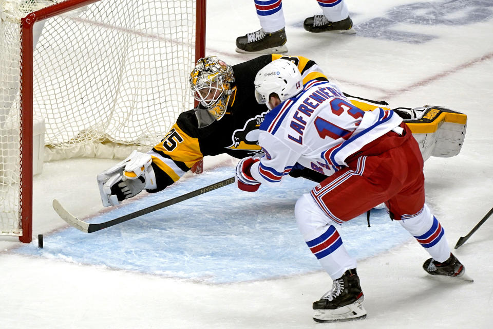 After losing his stick Pittsburgh Penguins goaltender Tristan Jarry (35) tries to make a save of a shot by New York Rangers' Alexis Lafreniere (13) during the first period of an NHL hockey game in Pittsburgh, Sunday, Jan. 24, 2021. (AP Photo/Gene J. Puskar)