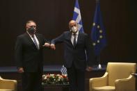 U.S. Secretary of State Mike Pompeo, left, and Greek Foreign Minister Nikos Dendias touch elbows during their meeting in the northern city of Thessaloniki, Greece, Monday, Sept. 28, 2020. Pompeo and Dendias, will sign a bilateral science and technology agreement, as well as host energy sector business leaders for a discussion to highlight energy diversification and infrastructure projects in Greece. (AP Photo/Giannis Papanikos, Pool)