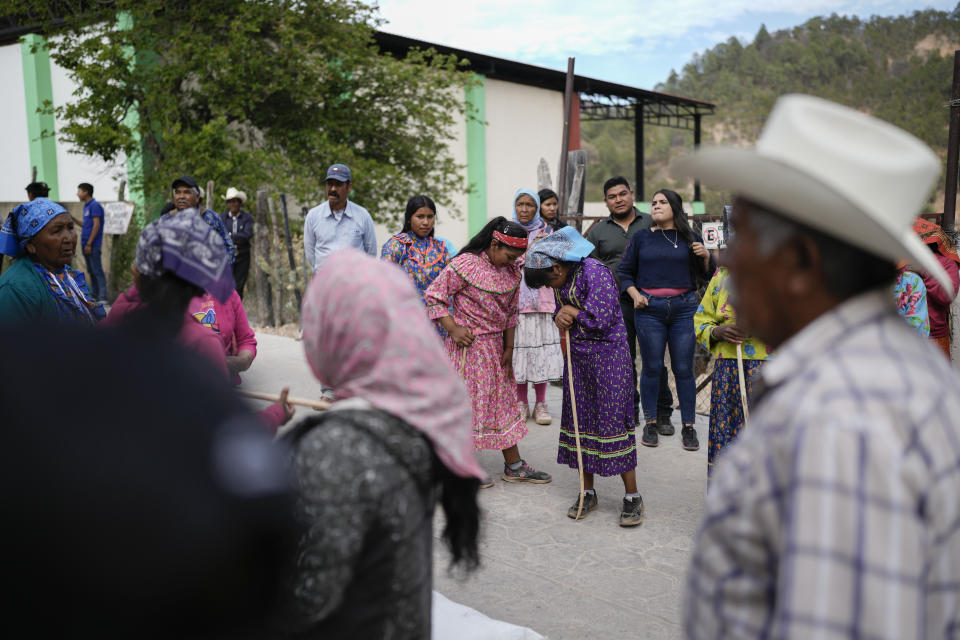 La corredora rarámuri Evelyn Rascón habla con una compañera de equipo antes del inicio de la carrera de Arihueta en Cuiteco, México, el sábado 11 de mayo de 2024. (AP Foto/Eduardo Verdugo)