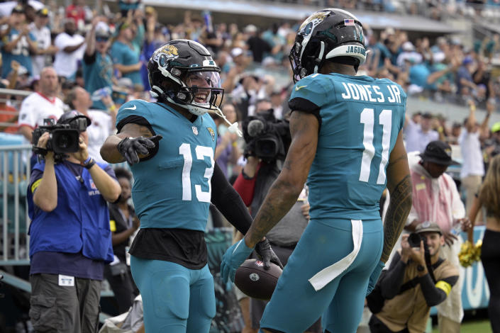 Jacksonville Jaguars wide receiver Christian Kirk (13) celebrates with Marvin Jones Jr. (11) after Kirk scored a touchdown against the Las Vegas Raiders in the second half of an NFL football game Sunday, Nov. 6, 2022, in Jacksonville, Fla. (AP Photo/Phelan M. Ebenhack)