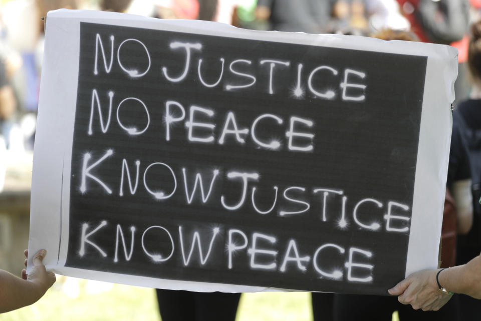 A sign is held during a protest over the deaths of George Floyd and Breonna Taylor, Tuesday, June 2, 2020, in Louisville, Ky. Floyd died after he was restrained by Minneapolis police on May 25. Taylor, a black woman, was fatally shot by police in her home in March. (AP Photo/Darron Cummings)