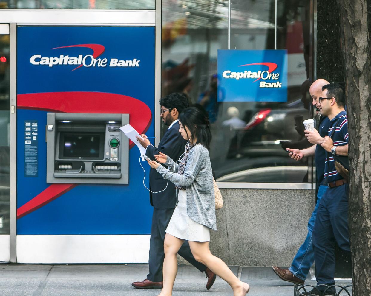 Capital One ATM on the streets of Manhattan with people walking by