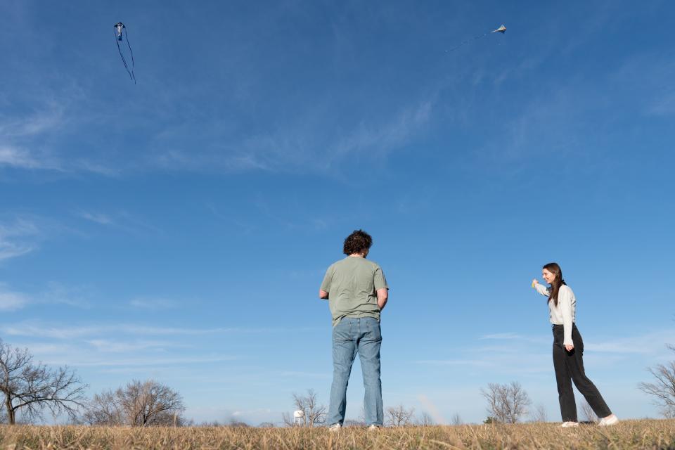 Jacob Schwartz and Katelyn Cofer take advantage of the warm weather and wind Wednesday to fly kites at Lake Shawnee.