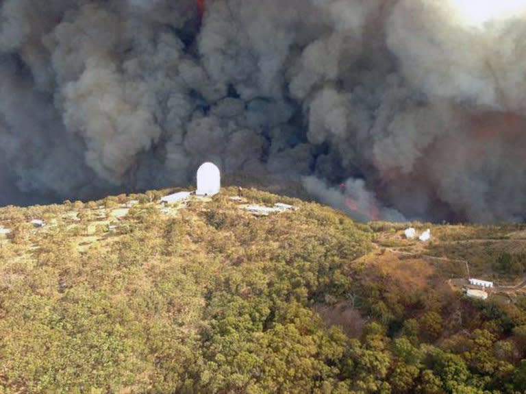 Photo taken on January 13, 2013 and provided by the New South Wales Rural Fire Service (RFS) shows smoke billowing from a fire near the Siding Spring Observatory. The RFS said that the main Anglo-Australian Telescope appear to have survived