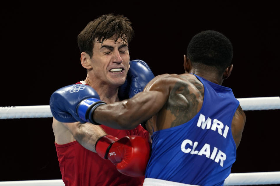 Aidan Walsh, of Ireland, in red, and Merven Clair, of Mauritius, trade punches during their welter weight 69kg quarterfinal boxing match at the 2020 Summer Olympics, Friday, July 30, 2021, in Tokyo, Japan. (AP Photo/Themba Hadebe)