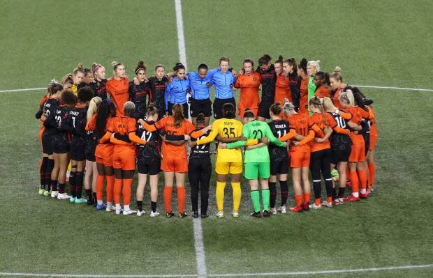 Portland Thorns and Houston Dash players, along with referees, gather at midfield, in demonstration of solidarity with two former NWSL players who came forward with allegations of sexual harassment and misconduct against a prominent coach, during the first half of an NWSL soccer match in Portland, Ore., Wednesday, Oct. 6, 2021. (Steve Dipaola/AP Photo - image credit)