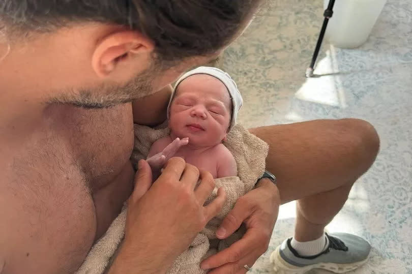 Joe Wicks holding his new baby