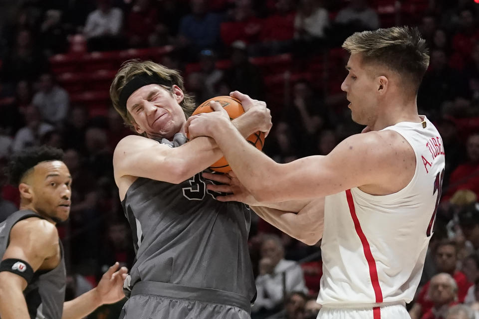 Utah center Branden Carlson, left, and Arizona forward Azuolas Tubelis vie for a rebound during the first half of an NCAA college basketball game Thursday, Feb. 24, 2022, in Salt Lake City. (AP Photo/Rick Bowmer)