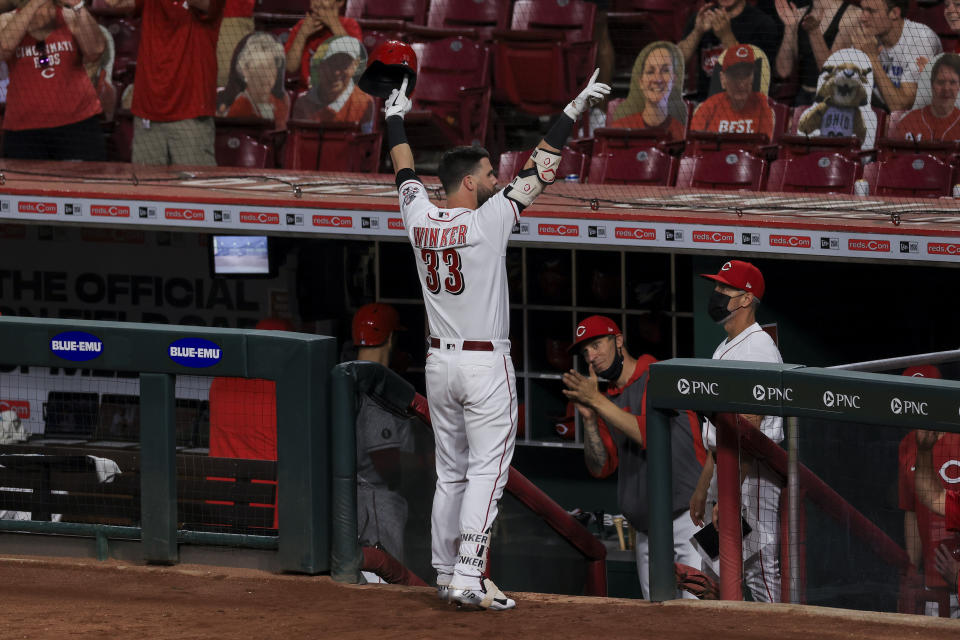 Cincinnati Reds' Jesse Winker acknowledges the fans after hitting a solo home run during the eighth inning of a baseball game against the Milwaukee Brewers in Cincinnati, Friday, May 21, 2021. The home run was his third of the game. (AP Photo/Aaron Doster)