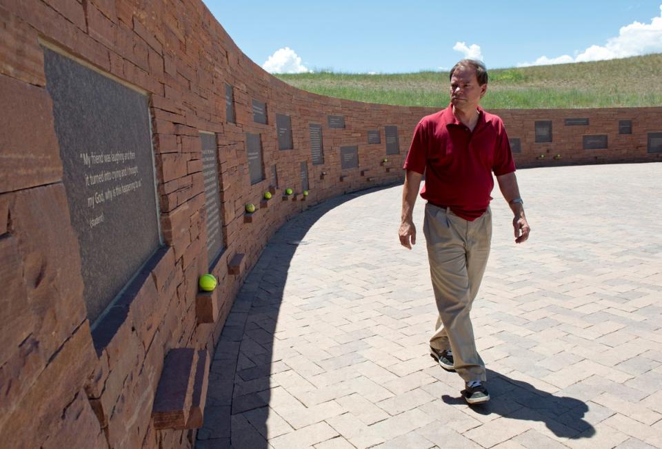 Tom Mauser, wearing the shoes of his 15-year-old son, Daniel – who was murdered during the Columbine school attack in 1999 – surveys the memorial opened in 2007 in a park behind the high school (AFP via Getty Images)