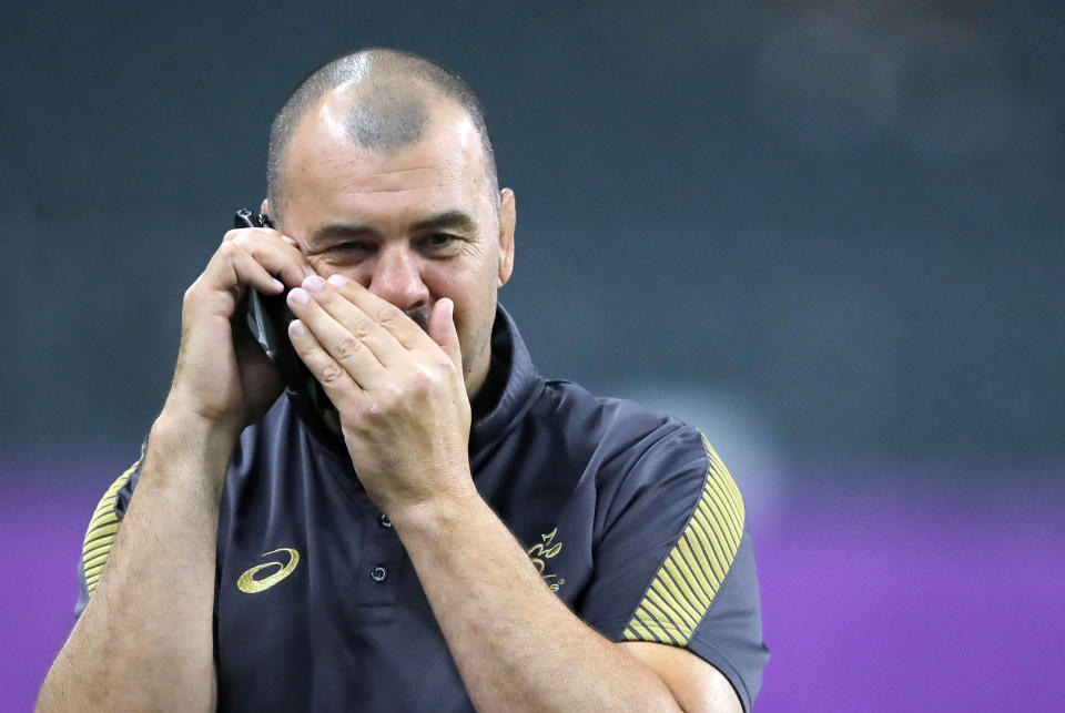 FILE - In this Oct. 18, 2019, file photo, Australia's rugby union coach Michael Cheika talks on a phone during a training session in Oita, Japan. Dave Rennie has been hired as Australia’s head coach to replace Cheika, who stood down following the Wallabies’ quarterfinal exit in October at the Rugby World Cup. (AP Photo/Christophe Ena, File)