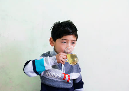 Murtaza Ahmadi, 7, an Afghan Lionel Messi fan, drinks tea in his house in Kabul, Afghanistan December 8, 2018. REUTERS/Mohammad Ismail