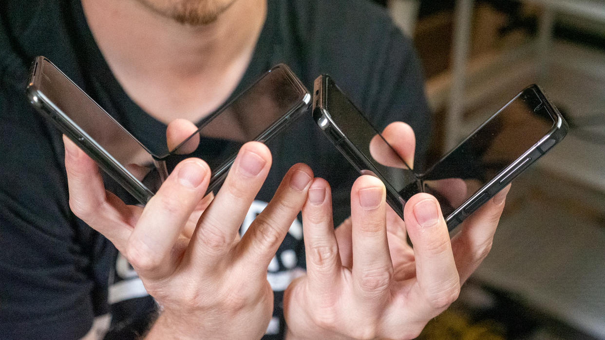  Holding the Motorola Razr+ and Samsung Galaxy Z Flip 5 next to each other partially folded 