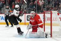 Arizona Coyotes center Logan Cooley (92) schores on Detroit Red Wings goaltender Alex Lyon (34) during the first period of an NHL hockey game, Thursday, March 14, 2024, in Detroit. (AP Photo/Carlos Osorio)
