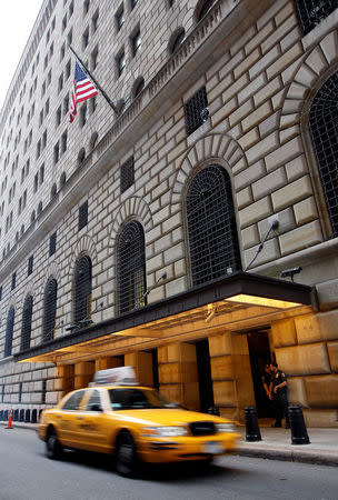 A taxi passes the Federal Reserve building in New York, September 14, 2008. REUTERS/Chip East/File Photo