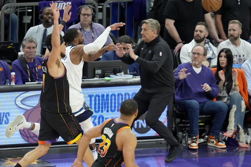 Minnesota Timberwolves head coach Chris Finch, right, tries to avoid Timberwolves guard Mike Conley, back left, after Conley was fouled by Phoenix Suns guard Devin Booker, left, during the second half of Game 4 of an NBA basketball first-round playoff series Sunday, April 28, 2024, in Phoenix. The Timberwolves won 122-116, taking the series 4-0. (AP Photo/Ross D. Franklin)