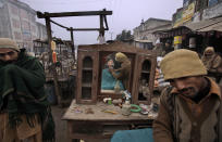 <p>A Pakistani street barber, right, gives a haircut to a customer, reflected in a mirror, in Gujranwala, near Lahore, Pakistan, Jan. 6, 2011. (Photo: Muhammed Muheisen/AP) </p>