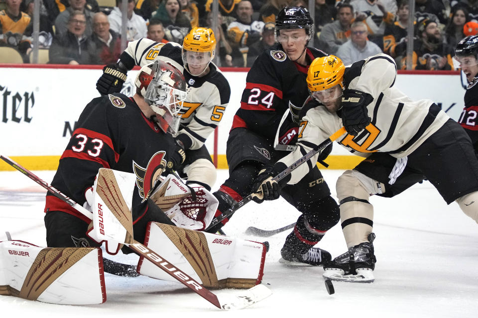 Pittsburgh Penguins' Bryan Rust (17) and Jake Guentzel (59) can't get to a rebound in front of Ottawa Senators goaltender Cam Talbot (33) with Jacob Bernard-Docker (24) defending during the second period of an NHL hockey game in Pittsburgh, Friday, Jan. 20, 2023. (AP Photo/Gene J. Puskar)