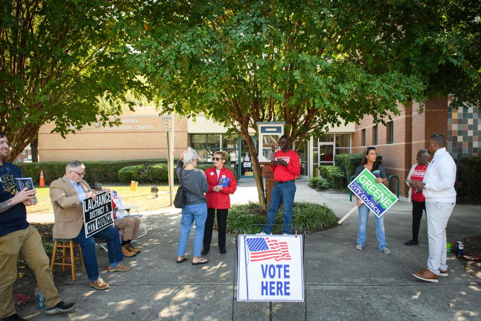 Candidates and volunteers wait to talk to voters as they go into the Kiwanis Recreation Center to vote on Tuesday, Oct. 10, 2023.