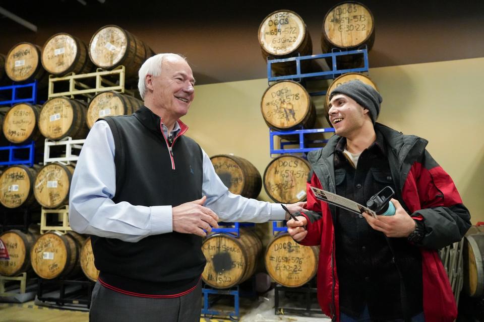 Republican presidential candidate Asa Hutchinson speaks to Brian Lazo Casanave after signing an autograph at Confluence Brewing Company on Wednesday, Jan. 3, 2024, in Des Moines.