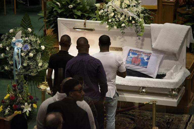 Friends, family and strangers came together to bury Gray, who lay in a casket next to a Los Angeles Dodgers baseball cap and a sign reading "Peace y'all"