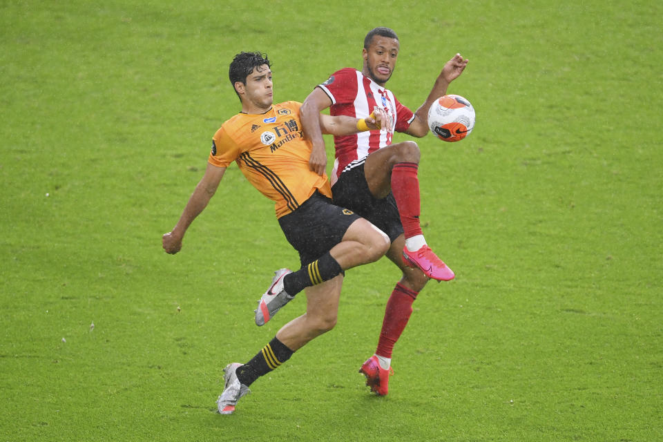 Raúl Jiménez (izquierda), del Wolverhampton, y Richairo Zivkovic, del Sheffield United, disputan un balón en un duelo de la Liga Premier inglesa, el miércoles 8 de julio de 2020 (Laurence Griffiths/Pool via AP)