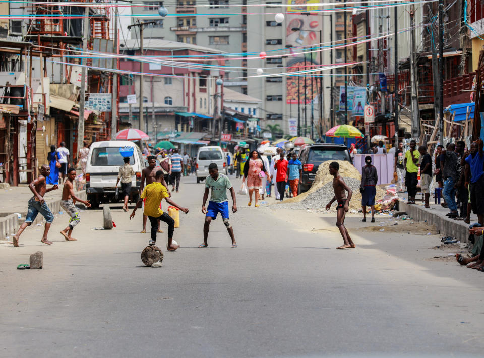 Boys play football on the street beside closed shops in a nearly deserted wholesale market during lockdown by the authorities to limit the spread of coronavirus disease (COVID-19), in Lagos