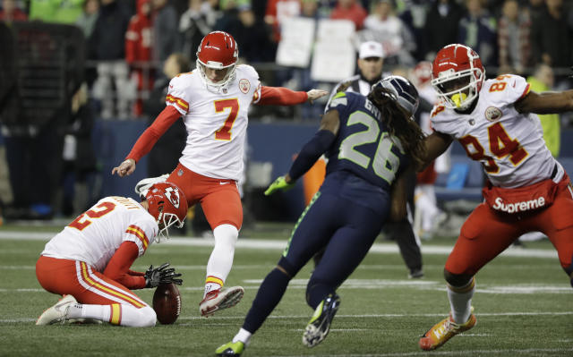 Kansas City Chiefs kicker Harrison Butker, top, is lifted by