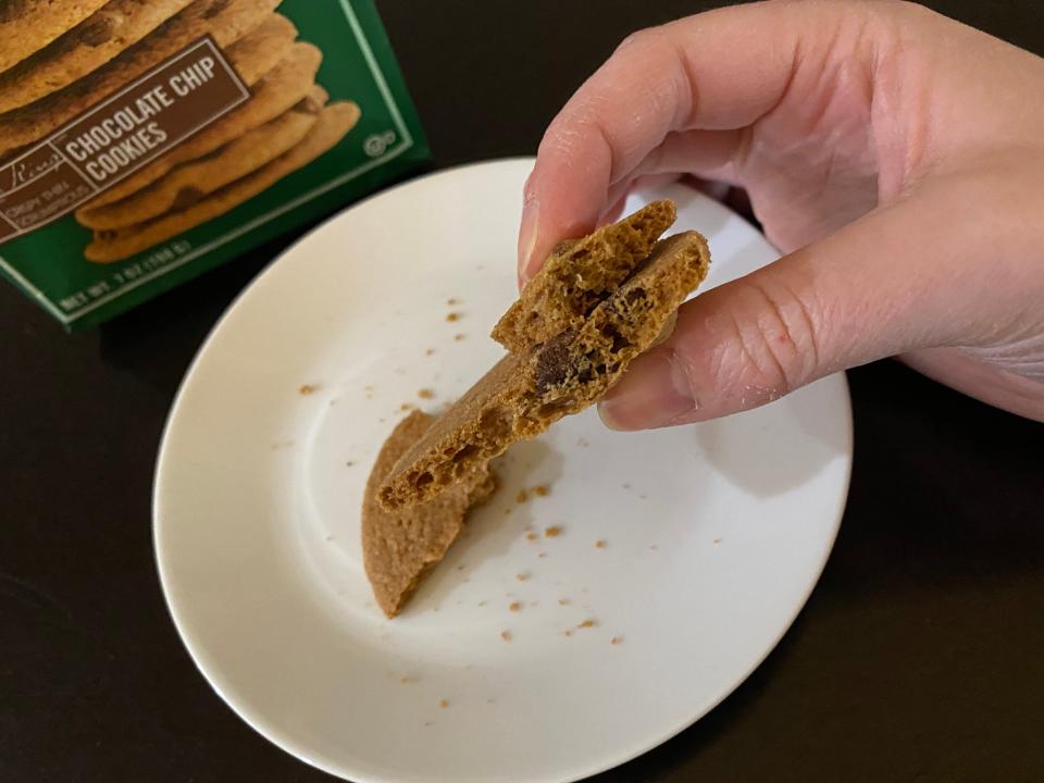 hand holding pieces of tates chocolate chip cookie