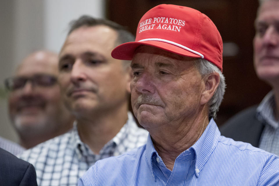 A guest wears a hat that reads "Make Potatoes Great Again" as President Donald Trump speaks at a meeting to support America's farmers and ranchers in the Roosevelt Room of the White House, Thursday, May 23, 2019, in Washington. (AP Photo/Andrew Harnik)