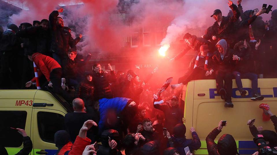 Football fans climb on a police van amid violent clashes before the Champions League clash between Liverpool and Roma at Anfield. Pic: Getty