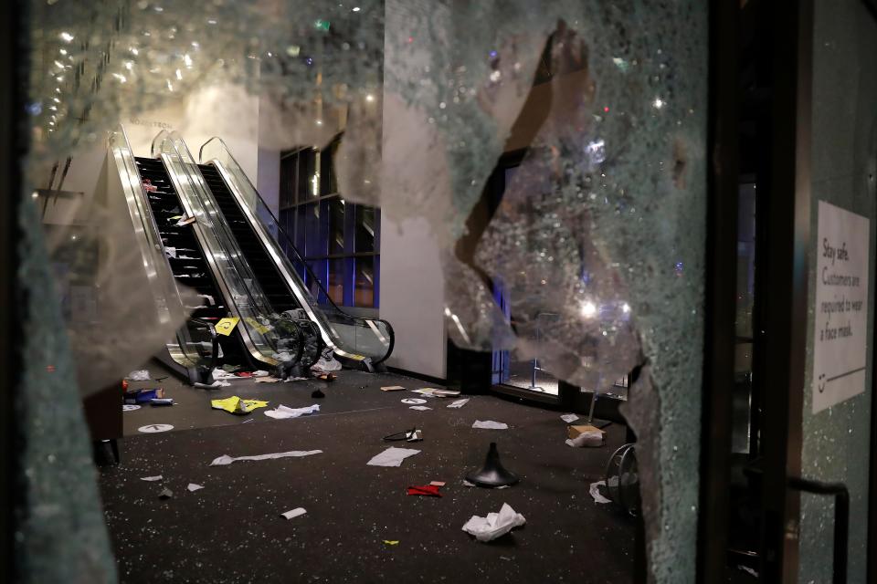 Glass is shattered in the Nordstrom store after a riot occurred in the Gold Coast area of the city early in the morning of Monday, Aug. 10, 2020 in Chicago.  Hundreds of people smashed windows, stole from stores and clashed with police in Chicago's Magnificent Mile shopping district and other parts of the city's downtown.