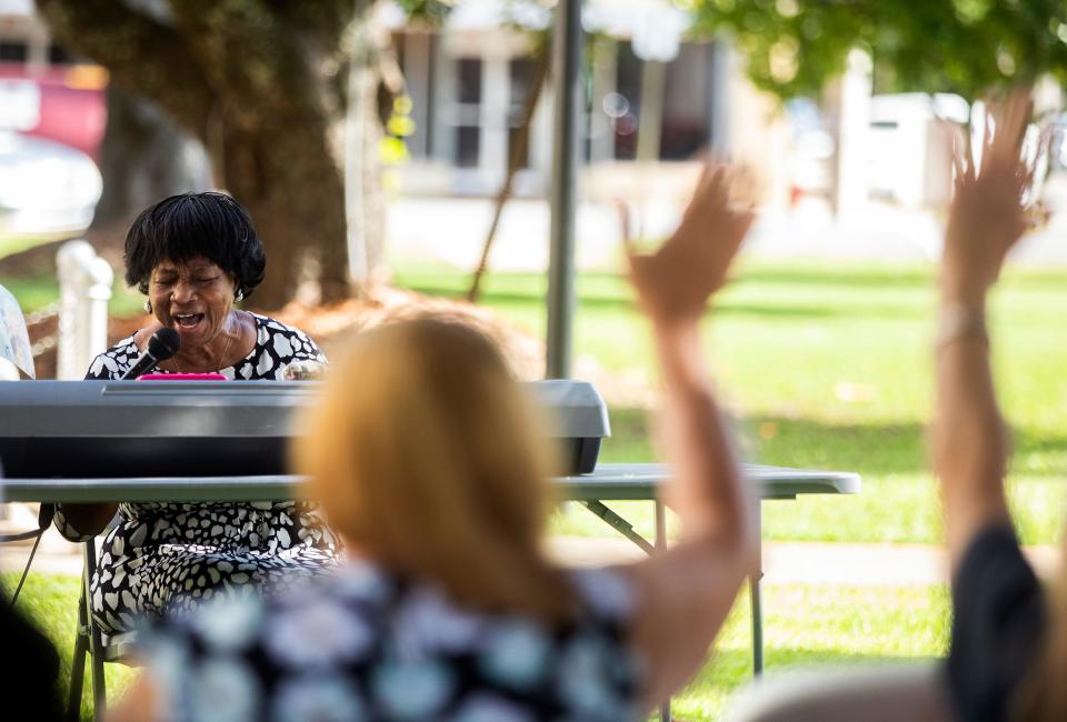 A woman sings and plays piano during an event Friday, July 8, 2022 beside the Gadsden County Courthouse in Quincy, Fla. to grieve those affected by the recent fentanyl overdoses. 