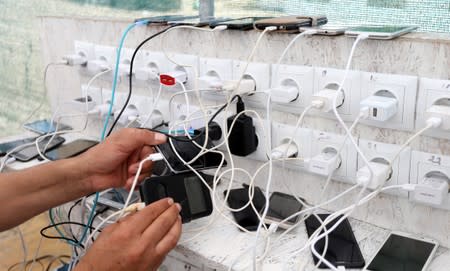 Migrants charge their phones in camp Vucjak in Bihac