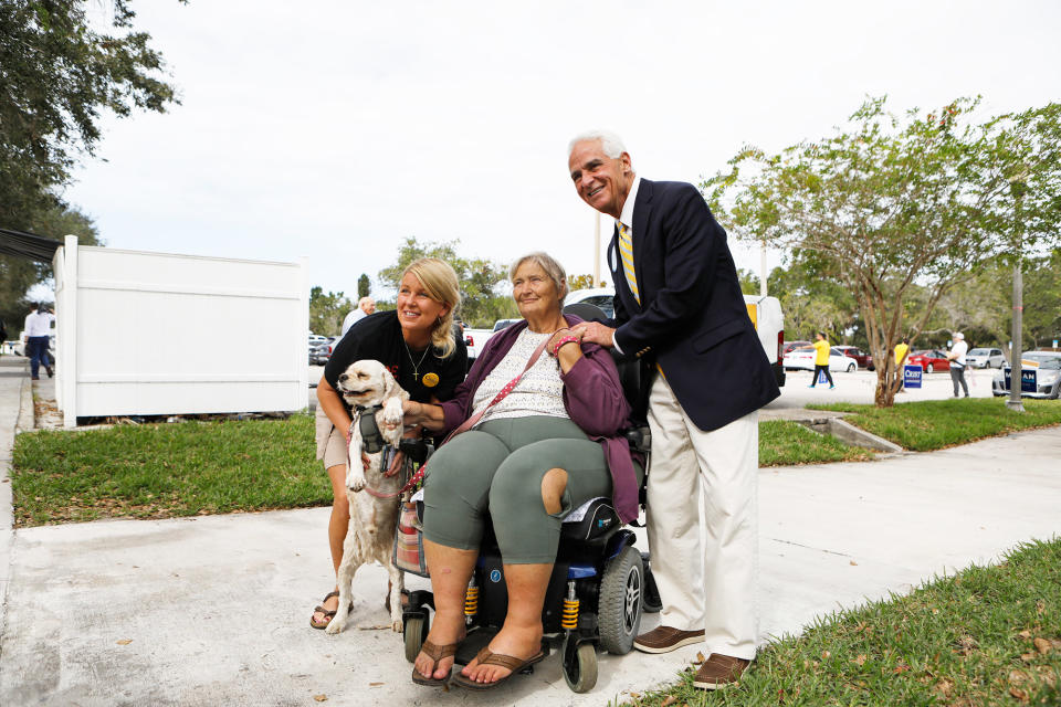 Democratic gubernatorial candidate Rep. Charlie Crist and his fiancé, Chelsea Grimes, take a photo with supporter Debra White and her dog, Victor, while Pinellas County residents cast their voting ballots at a polling precinct on Nov. 8, 2022, in St. Petersburg, Florida.