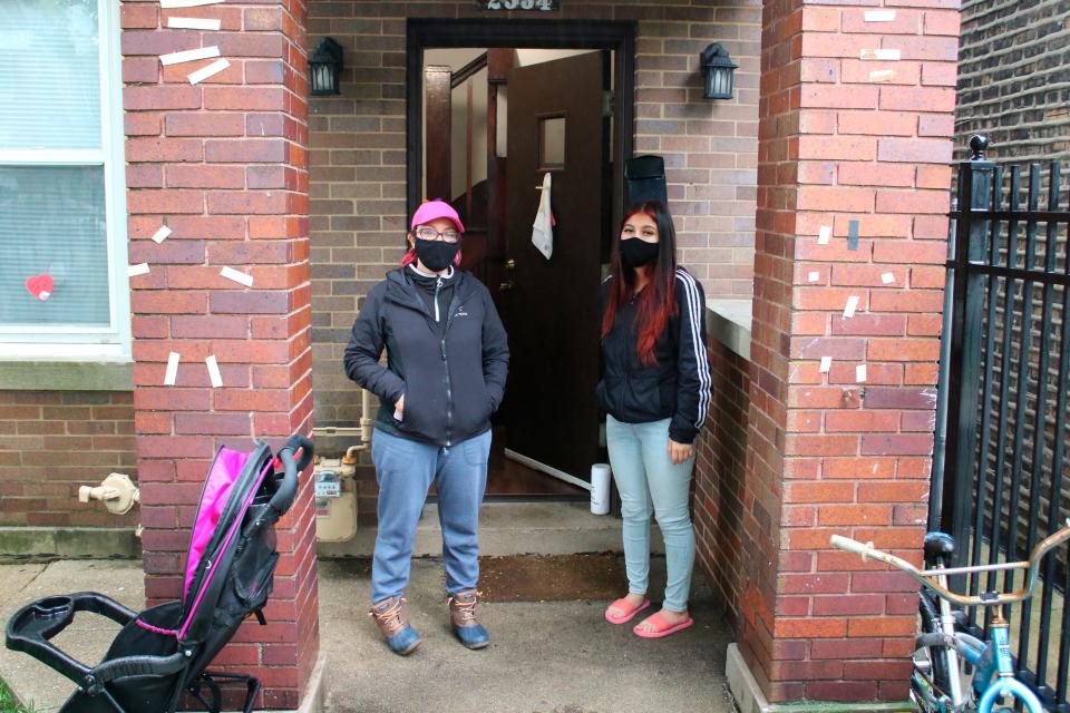 In this May 14, 2020 photo, Erendira Martinez and her daughter stand outside their home in the Little Village neighborhood of Chicago.  Chicago’s Little Village neighborhood is known as the heart of Mexican culture in the city. It’s also located in the zip code area with one of the highest rates of positive coronavirus cases in the city.  Both Martinez and her daughter, along with Martinez' husband, tested positive for COVID-19. All have since recovered.  (AP Photo/Noreen Nasir) ORG XMIT: RPNN104