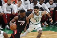 Miami Heat's Jimmy Butler (22) drives past Boston Celtics' Jayson Tatum (0) during the first half of Game 3 of the NBA basketball playoffs Eastern Conference finals Saturday, May 21, 2022, in Boston. (AP Photo/Michael Dwyer)