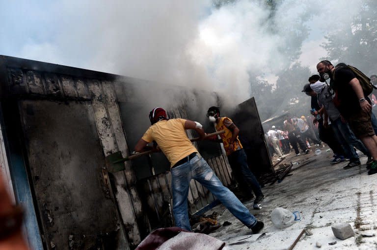 Demonstrators try to extinguish a fire in a container used for construction workers in Taksim square in Istanbul on June 4, 2013