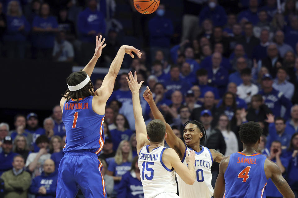 Florida's Walter Clayton Jr. (1) hits a three point shot while defended by Kentucky's Reed Sheppard (15) and Rob Dillingham (0) in the closing seconds of the second half of an NCAA college basketball game sending it into overtime Wednesday, Jan. 31, 2024, in Lexington, Ky. Florida won in overtime 94-91. (AP Photo/James Crisp)