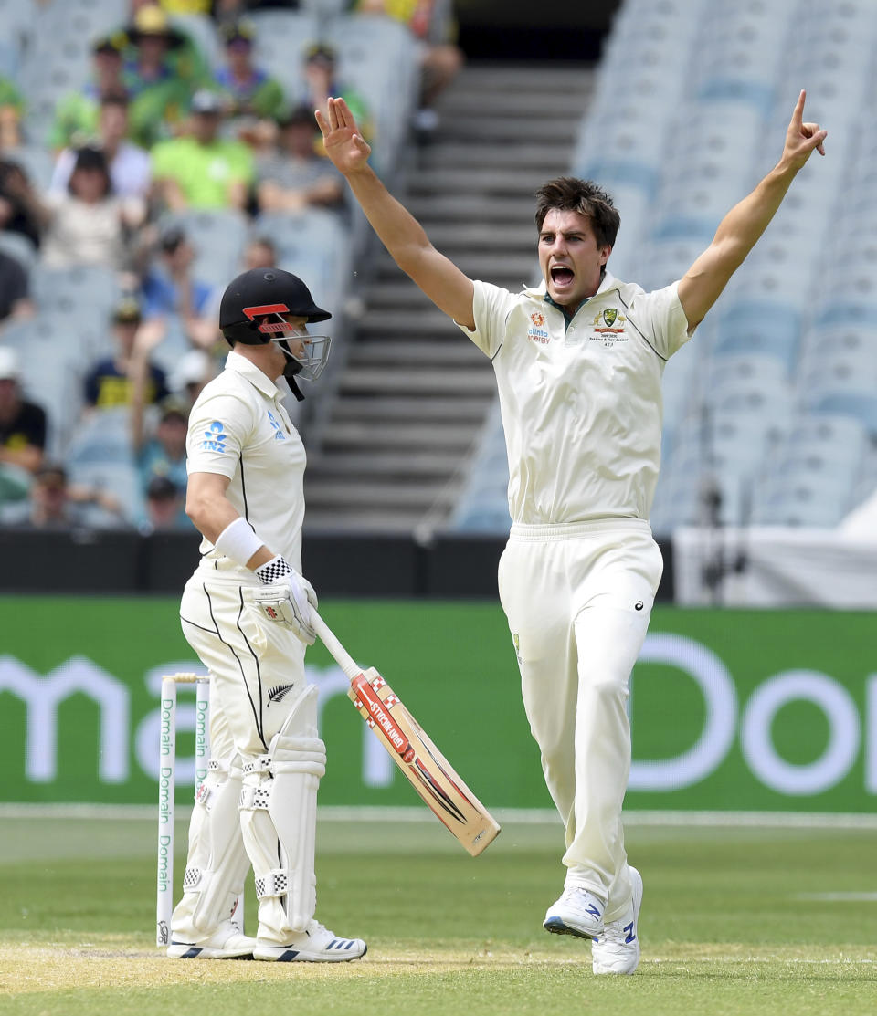 Australia's Pat Cummins, right celebrates the wicket of New Zealand's Henry Nicholls, left, during a cricket test match in Melbourne, Australia, Saturday, Dec. 28, 2019. (AP Photo/Andy Brownbill)