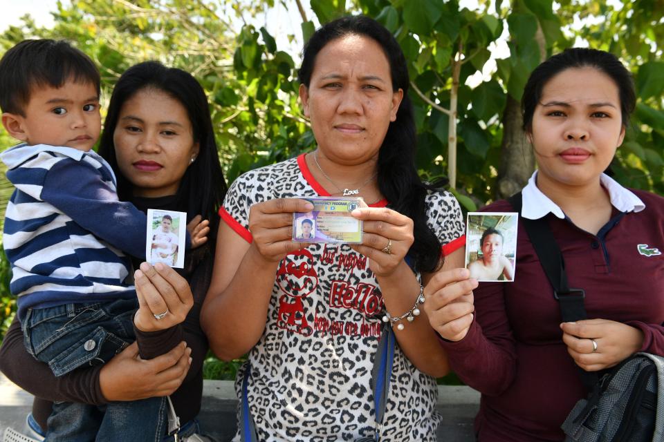 Women show photos of their husbands who are still missing one year after the Marawi siege.